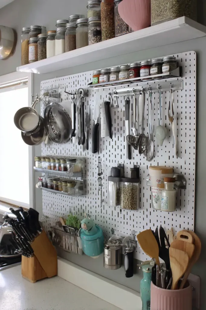 Functional kitchen wall with pegboard, hanging utensils, and spice storage.