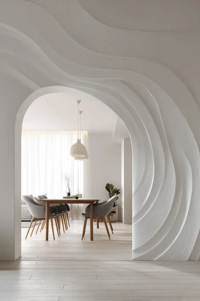 White abstract wave wall art structuring an open-plan space while keeping it light and fluid.