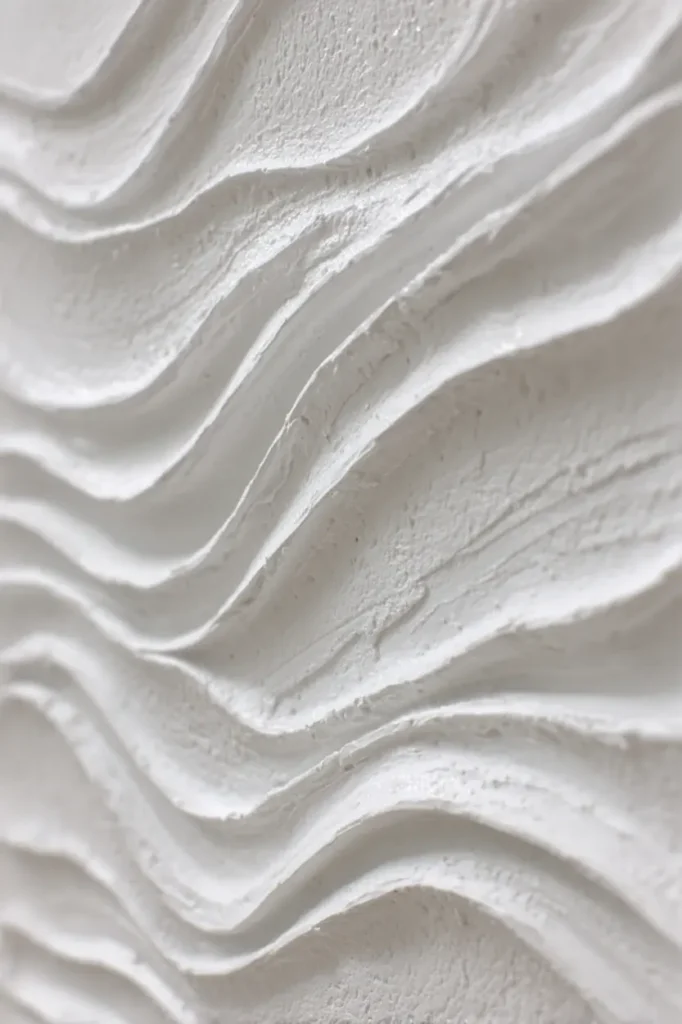 Close view of white textured wave wall art showing how light reveals emotion through material.
